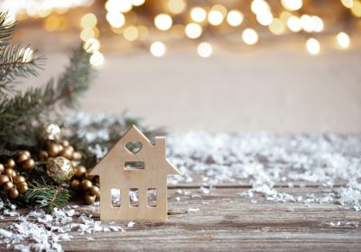 Winter cozy background with festive decor details, snow on a wooden table and bokeh. The concept of a festive atmosphere at home.