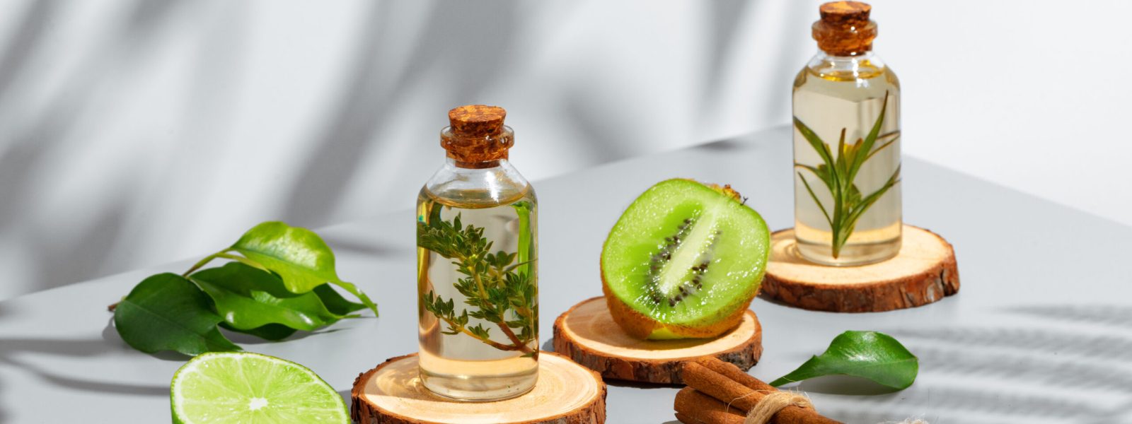 Fruit essential oil in glass bottle on gray background, close up