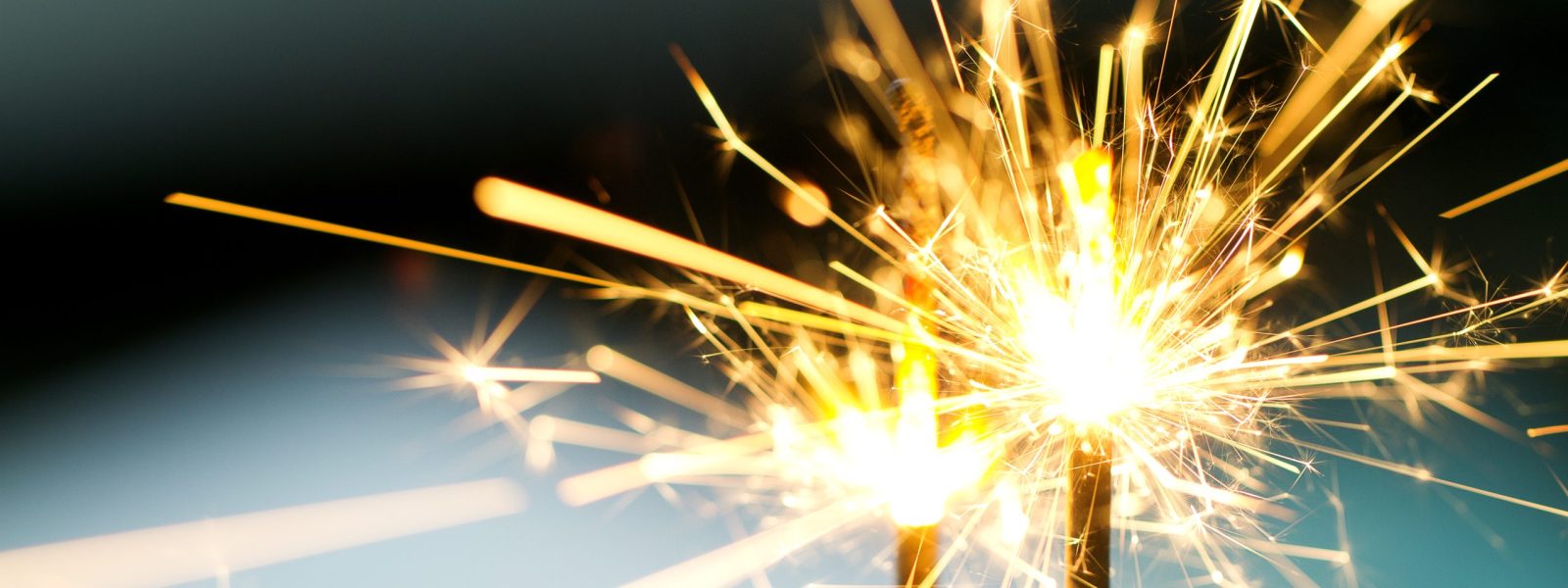 Closeup of sparks glimmering in night while fireworks burning.