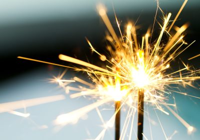 Closeup of sparks glimmering in night while fireworks burning.